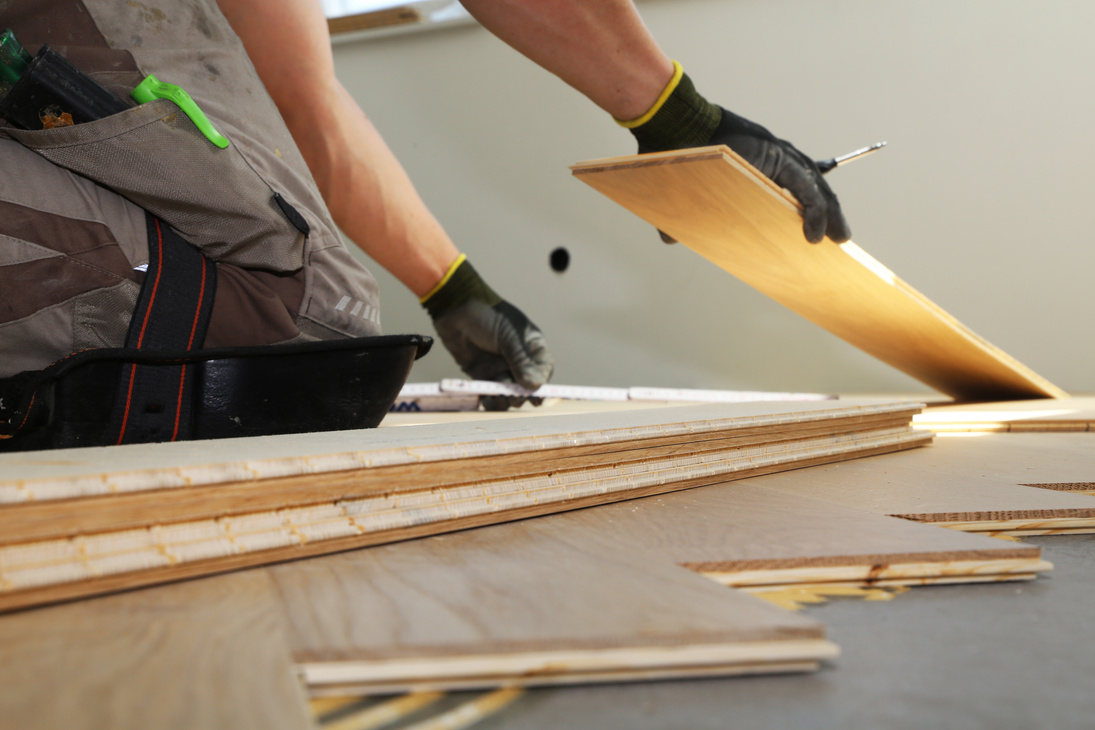 Craftsman laying herringbone parquet flooring professionally